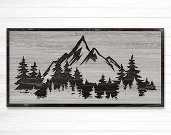 May include: Black and white silhouette of a mountain range with trees in front of it. The image is on a wood background.