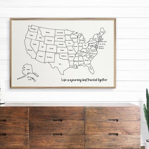 May include: A black and white outline map of the United States with each state labeled. The map is on a beige background with the text "Life is a journey best traveled together" at the bottom.