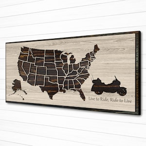 May include: A wooden sign with a cutout of the United States map and a motorcycle. The text "Live to Ride, Ride to Live" is below the motorcycle.