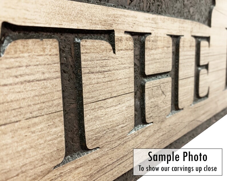 May include: Close-up of a wooden sign with the word "THE" carved into it. The letters are black and the wood is a light brown color. The sign is a sample photo to show the detail of the carving.