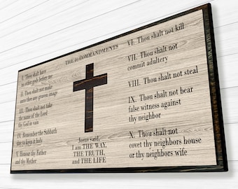 Könnte beinhalten: Ein Holzschild mit den Zehn Geboten in schwarzer Schrift. Das Schild zeigt auch ein Holzkreuz und ein Zitat von Jesus: "Ich bin der Weg, die Wahrheit und das Leben."