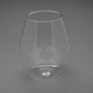 May include: A clear glass wine glass with a rounded base and a wide, open mouth.