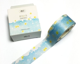 May include: A roll of blue and white washi tape with a pattern of yellow stars and waves. The tape is labeled "Candy Poetry - masking tape - ".