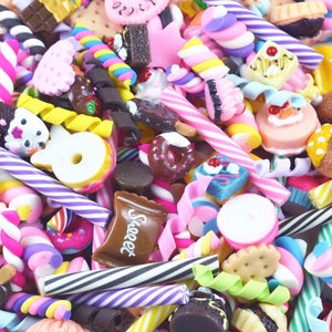 May include: A colorful assortment of miniature candy and sweets, including lollipops, candy canes, chocolate bars, and donuts. The items are arranged in a pile and appear to be made of polymer clay.