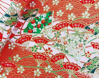 Op de afbeelding: Rood en gouden cadeaupapier met een traditioneel Japans ontwerp met waaiers, bloemen en golven.