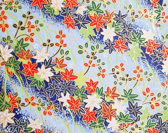 May include: A blue and white patterned paper with a repeating design of red, green, and white flowers. The paper has a subtle gold shimmer.