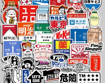 May include: A selection of colourful stickers with Japanese-themed designs. The stickers include images of Mount Fuji, Coca-Cola, Kit Kat, and various Japanese text and logos. The stickers are of various shapes and sizes.