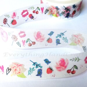Peut inclure: Ruban washi blanc avec un motif répété de fleurs roses, d'oiseaux bleus, de cerises, de fraises et de cœurs. Le ruban est sur un fond blanc.