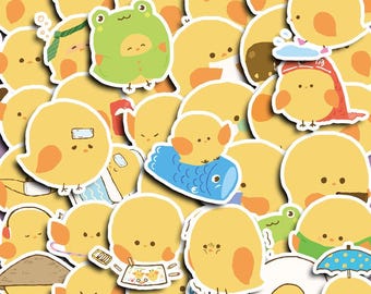 May include: A selection of yellow chick stickers with orange detailing. Some chicks are wearing costumes, such as a frog hat, a red hat, and a blue fish. Other stickers depict chicks with bandages, headphones, and umbrellas.