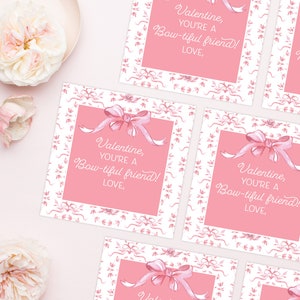 May include: Pink Valentine's Day cards with a white border and a pink bow. The cards have the text "Valentine, you're a bow-tiful friend! Love," printed on them.