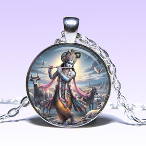 May include: A silver necklace with a round glass pendant featuring a colorful image of Krishna playing a flute surrounded by cows and birds. The pendant has a silver border.