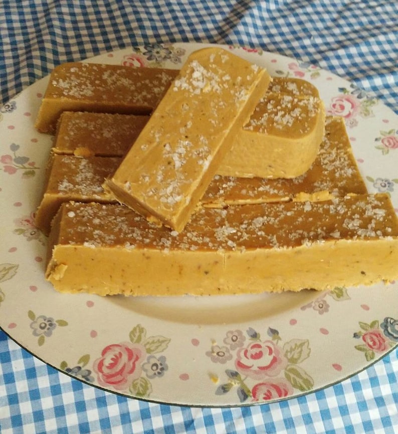 May include: A plate of homemade fudge bars with a light brown colour and a sprinkle of salt on top.