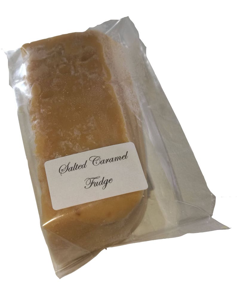 May include: A pack of salted caramel fudge. The fudge is a light brown colour and is wrapped in clear plastic. The pack has a white label that says "Salted Caramel Fudge".