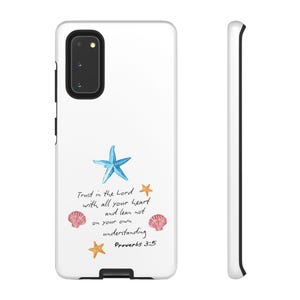 Könnte beinhalten: Eine weiße Handyhülle mit einem blauen Seestern, zwei orangefarbenen Seesternen und zwei rosa Muscheln. Der Text lautet: Trust in the Lord with all your heart and lean not on your own understanding Proverbs 3:5. Die Hülle hat einen schwarzen Ausschnitt.