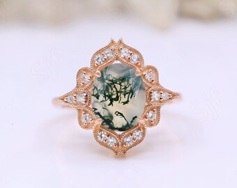 May include: A rose gold engagement ring with a green and white agate gemstone surrounded by a halo of small diamonds.
