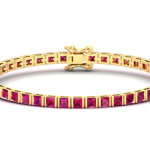 May include: A gold tennis bracelet with a row of pink square-shaped gemstones.