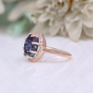 May include: A rose gold engagement ring with a large, round, blue gemstone surrounded by a halo of smaller, clear gemstones.