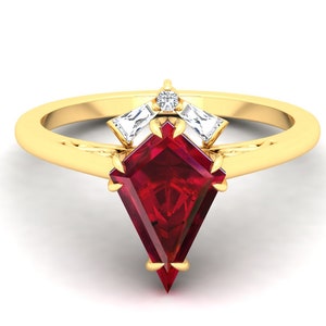 Op de afbeelding: Een gouden ring met een grote, rode, gefacetteerde edelsteen in het midden. Twee kleinere, heldere, gefacetteerde edelstenen zijn boven de middelste steen geplaatst.