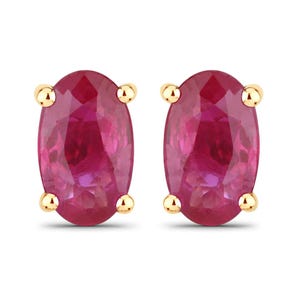 May include: A pair of oval-shaped ruby earrings set in gold.