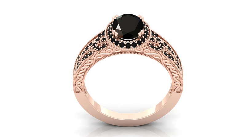 May include: A rose gold engagement ring featuring a black diamond centre stone and a halo of smaller black diamonds. The band is decorated with intricate scrollwork.