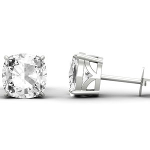 May include: A pair of silver stud earrings with a large, clear, cushion-cut gemstone in each earring.