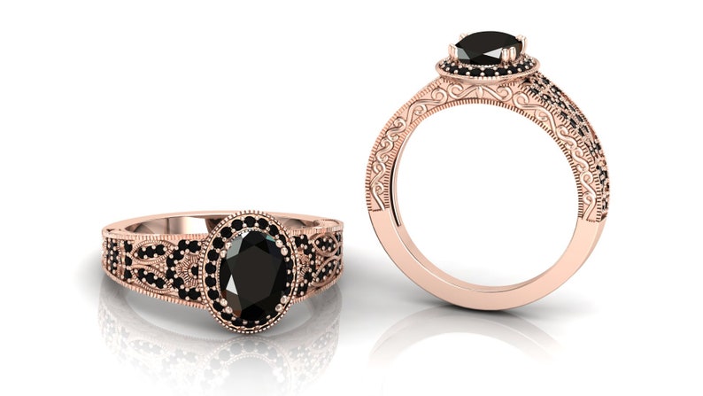 May include: A rose gold engagement ring featuring an oval black diamond surrounded by smaller black diamonds. The band is adorned with intricate scrollwork and black diamonds.