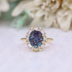 May include: A gold ring with a large oval-shaped blue gemstone surrounded by a halo of smaller diamonds. The ring has a delicate band.