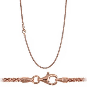 May include: A rose gold chain necklace with a lobster clasp closure. The chain is made of small, round links.