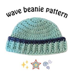 May include: A light mint green crochet beanie with a dark navy blue band and a ribbed brim. The text "wave beanie pattern" is printed above the hat, with a yellow sparkle icon, a multi-coloured star, and two purple swirl icons below it.