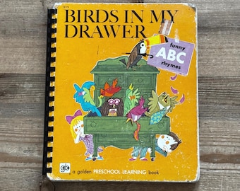 May include: A vintage children's book titled "Birds in My Drawer" with a yellow cover. The cover features colorful cartoon birds and a green dresser. A sticker reads "funny ABC rhymes." The book is a golden preschool learning book.