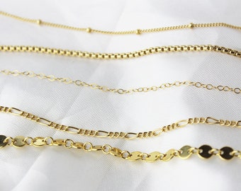 Può includere: Cinque catene d'oro di diversi stili e lunghezze, tra cui una catena con piccole perline rotonde, una catena con piccoli anelli quadrati, una catena con anelli ovali, una catena con anelli rettangolari e una catena con anelli rotondi a forma di disco.