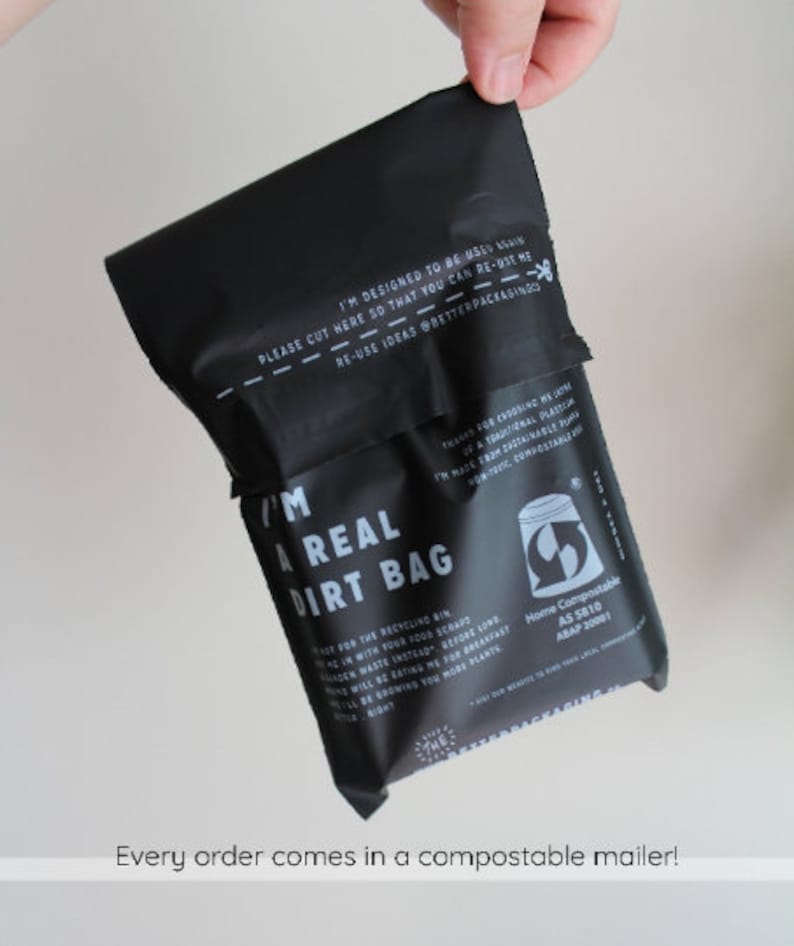 May include: A black compostable mailer bag with the text "I'm a real dirt bag" and "Home Compostable AS 5810 AS/NZS 4738:2003". The bag is designed to be reused and has a cut line with the text "Please cut here so that you can re-use me - Re-use ideas @betterpackagingco".