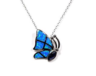 May include: A silver chain necklace with a blue opal butterfly pendant. The butterfly has black accents and a small blue gemstone in the center.