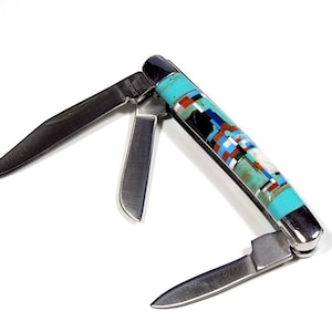 May include: A multi-blade pocket knife with a decorative handle. The handle has a mosaic design with turquoise, black, white, red, and blue inlays. The stainless steel blades are open, revealing their sharp edges.
