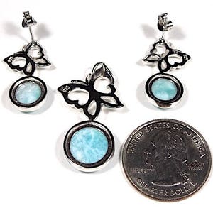 May include: Sterling silver butterfly earrings and pendant with a blue gemstone. The earrings and pendant feature a delicate butterfly design with a round blue gemstone in the center.