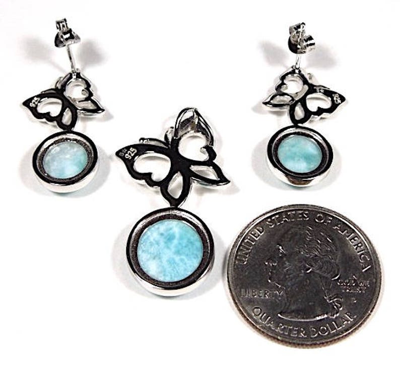 May include: Sterling silver butterfly earrings and pendant with a blue gemstone. The earrings and pendant feature a delicate butterfly design with a round blue gemstone in the center.