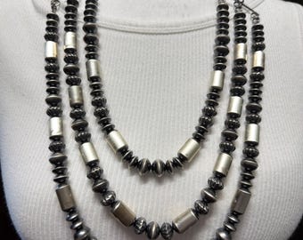 Collar de 67 cm de largo, de 3 hebras escalonadas con perlas navajo surtidas y cuentas de plata de ley.