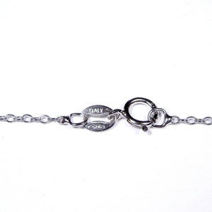 May include: A silver chain necklace with a lobster clasp closure. The clasp has a small tag that reads "ITALY 925".
