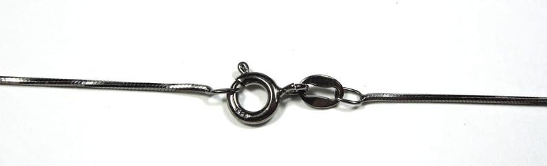 May include: A silver chain necklace with a lobster clasp closure.