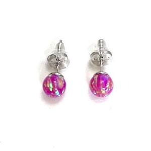 May include: A pair of silver stud earrings with pink iridescent round stones.