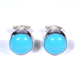 May include: A pair of silver stud earrings with round turquoise stones.