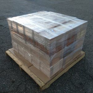 May include: A stack of wooden boxes wrapped in clear plastic, sitting on a wooden pallet. The boxes are stacked in a rectangular shape and are all the same size.