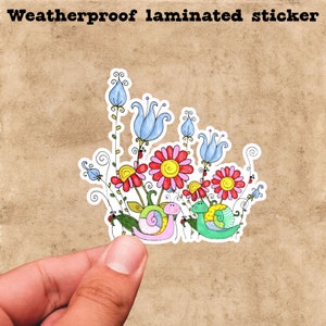 May include: Weatherproof laminated sticker featuring two snails with colorful shells, surrounded by flowers with red, pink, and yellow petals. The snails are in a garden setting with blue flowers and green leaves.