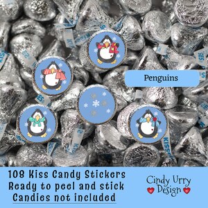 May include: 108 round stickers featuring penguins wearing scarves and hats on a blue background with snowflakes. The stickers are designed to be placed on Hershey's Kisses chocolate candies. The text "Penguins" and "Cindy Urry Design" are also included in the image.