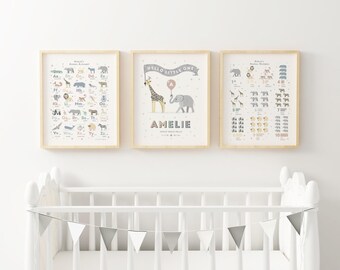 May include: Three framed nursery art prints with animal illustrations. The prints include an animal alphabet, a personalized print with a giraffe and elephant, and an animal numbers chart. The prints are in light wood frames and are displayed above a white crib.