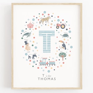 Peut inclure: Une affiche encadrée avec la lettre « T » rayée bleu clair, entourée d'illustrations colorées d'animaux et d'objets, comme un tigre et un train. Le texte « T is for THOMAS » est en bas.