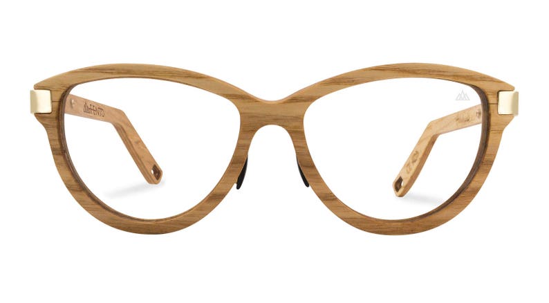 May include: A pair of cat-eye glasses with a wooden frame and clear lenses. The frame is a light brown color with a gold accent on the temples.