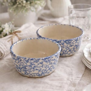 May include: A set of three ceramic mugs with a speckled, matte finish. The mugs are in shades of cream, light gray, and dark gray. Each mug has a simple, minimalist design, perfect for coffee or tea.