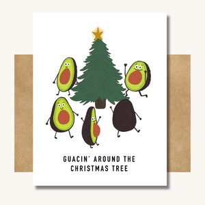 May include: A Christmas card with a green Christmas tree and five avocado halves with faces dancing around the tree. The text on the card reads "Guacin' around the Christmas tree."