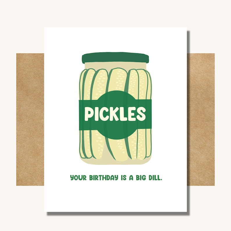 May include: A white card with a green jar of pickles. The jar has a green label that says 'PICKLES'. The text on the card reads 'YOUR BIRTHDAY IS A BIG DILL.'